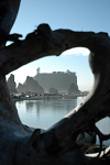 Driftwood window looking over a pond where two boys were skipping stones. A large sea stack is seen in the distance.